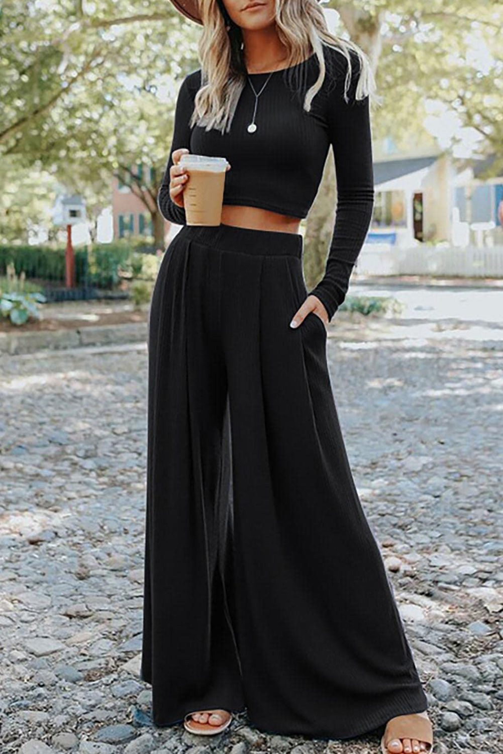 Woman holding a coffee wearing the Black Ribbed Crop Top and Long Pants Set. Front view